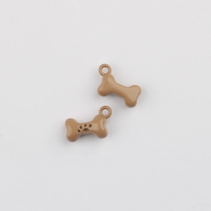 Close-up of brown bone-shaped alloy charms with paw print for DIY jewelry making