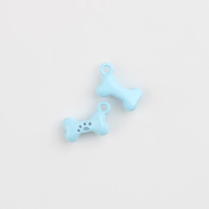 Macro detail of light blue bone-shaped alloy pendants with black paw print for DIY jewelry