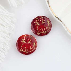 Detail of red Czech glass beads with gold cat pattern for DIY jewelry making