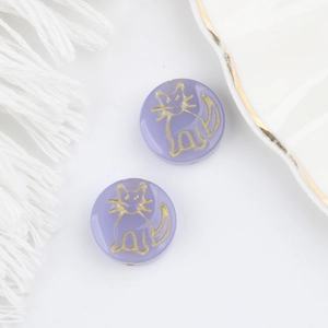 Macro shot of purple Czech glass beads with golden cat patterns for DIY jewelry making