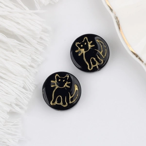 Detail of round black glass beads with golden cat patterns for DIY jewelry making