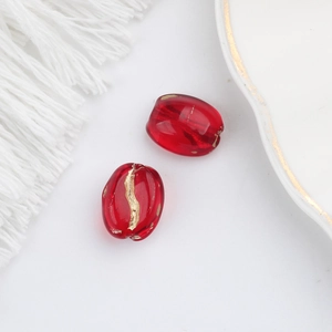 Macro detail of red oval glass beads with gold foil texture for DIY jewelry making