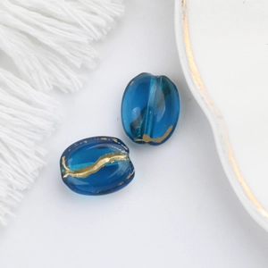 Detailed view of blue transparent glass beads with gold foil accents for DIY jewelry