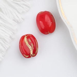 Macro detail of red Czech glass oval beads with gold foil texture for DIY jewelry making