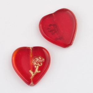 Macro detail of red heart-shaped glass beads with gold rose pattern for DIY jewelry