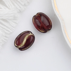 Close-up of translucent coffee bean beads with gold-rimmed edges for DIY jewelry making