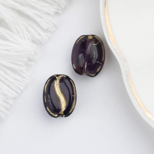 Macro detail of purple Czech glass coffee bean beads with vintage gold gilded texture