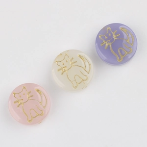 Detailed view of round Czech glass beads with gold engraved cat patterns for DIY crafts
