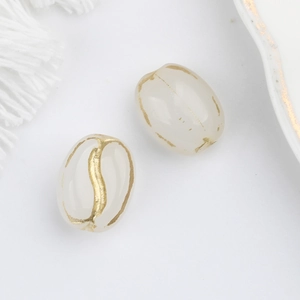 Detail of oval cream Czech glass beads with hand-painted gold coffee bean grooves