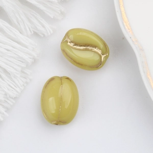 Close-up of olive green glass beads with gold etched coffee bean patterns for DIY jewelry