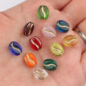 Hand holding colorful coffee bean glass beads with gold accents for DIY jewelry