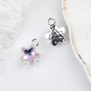 Detail of 11mm star pendant featuring purple zircon and hammered silver texture for DIY jewelry