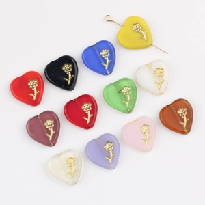 Macro view of heart-shaped Czech glass beads with gold rose carvings for DIY jewelry