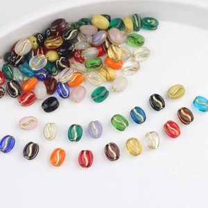 Macro shot of glass coffee bean beads with gold gilded accents for DIY jewelry crafts