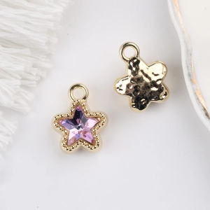Detail of 11mm star pendant featuring purple zircon crystal and hammered gold texture