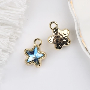 Detail showing the blue zircon star pendant with golden beaded edge and hammered back texture