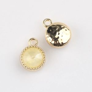 Detail of yellow gemstone pendant with gold beaded edge and hammered texture back
