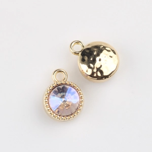 Detailed view of DIY jewelry charms with faceted iridescent crystals and gold metal back