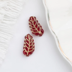 Macro detail of deep red leaf glass beads with gold gilding veins for DIY jewelry