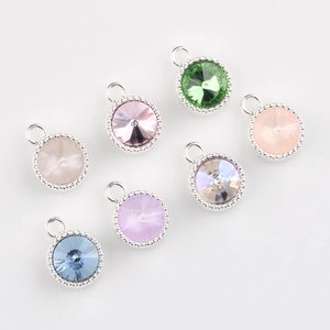 Flat lay of seven colorful round crystal pendants with milgrain silver metal edges