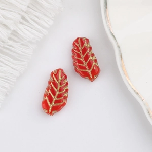 Macro detail of red Czech glass leaf beads with gold veins and vintage finish