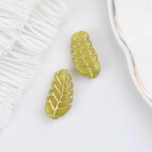 Close-up of olive green Czech glass leaf beads with gold-painted veins for jewelry making