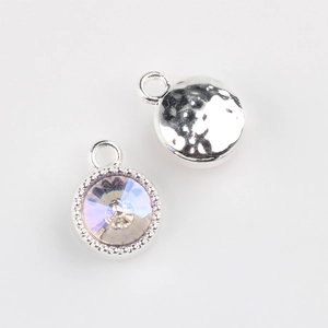 Macro detail of alloy round pendant featuring faceted crystal and hammered metal texture
