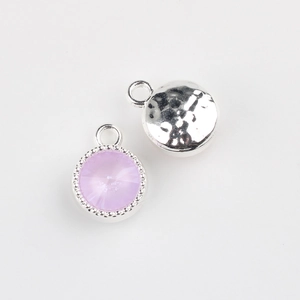 Detail of round alloy pendants with purple faceted crystal and hammered metal back textures
