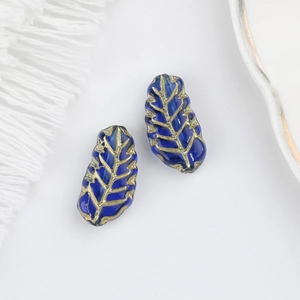 Detail of leaf-shaped dark blue Czech glass beads with gold veins for DIY jewelry