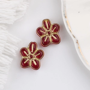 Macro detail of red and gold glass five-petal flower beads for DIY jewelry making