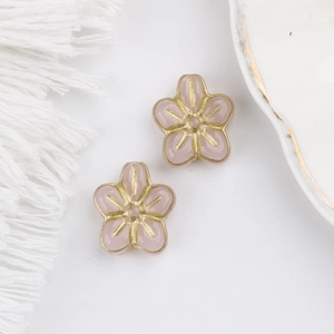 Macro detail of pink glass five-petal flower beads with golden edges for DIY jewelry