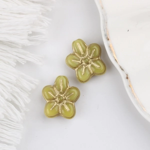 Close-up of yellow-green Czech glass flower beads with gold edges for DIY jewelry