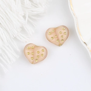 Dettaglio di perline in vetro ceco rosa a cuore con pois dorati per creazione di gioielli