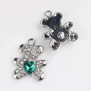 Détail du pendentif ours argenté avec strass pavés et pierre précieuse verte en cœur