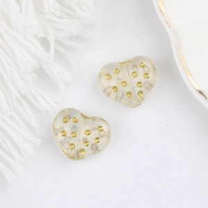 Dettaglio delle perle di vetro ceche a forma di cuore con pois dorati per gioielli fai da te