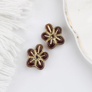 Detail of amber glass five-petal flower beads with gold gilding for DIY jewelry making