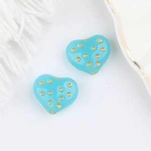 Dettaglio di perle in vetro ceco a forma di cuore blu cielo con pois dorati fini
