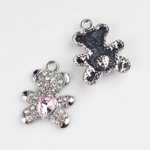 Détail de breloques ours en argent avec zircons pavés et cristal de cœur rose