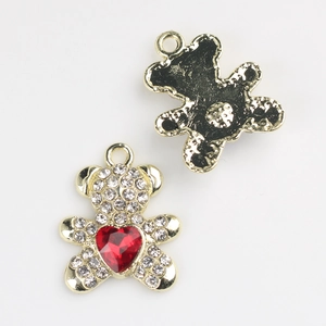 Détail du pendentif ours avec strass blancs et cœur rouge sur socle en métal doré