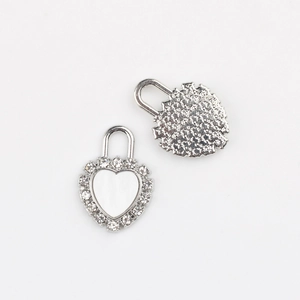 Detailed view of silver heart lock pendants with cubic zirconia inlay for DIY jewelry