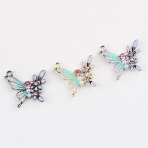Detailed view of three enamel butterfly pendants with zircons and faux pearls for DIY jewelry