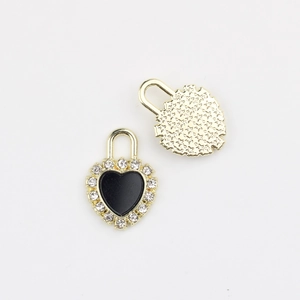 Macro detail of heart lock pendant with zircon inlay and gold star patterned back
