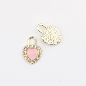 Detailed view of gold heart lock charm with pink enamel center and cubic zirconia bezel