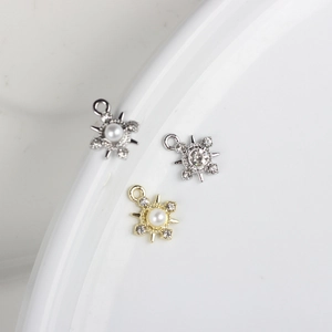 Detalle macro de colgantes de copo de nieve con perlas y circonitas para bisutería