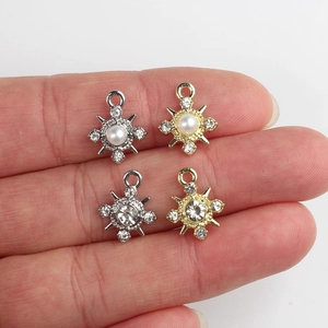 Vista macro de dijes de copo de nieve de aleación con perlas y circón para joyería DIY