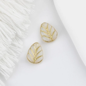 Macro detail of leaf-shaped Czech glass beads with double-sided gold-painted veins