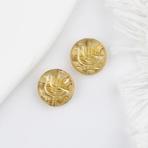 Macro shot of two yellow translucent duck beads with gold details for jewelry DIY