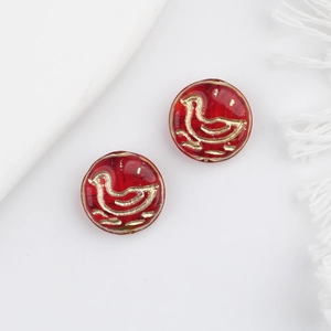 Macro view of translucent red Czech glass beads with gold duck pattern for DIY jewelry