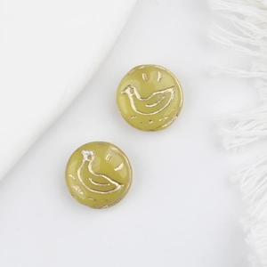Detail of vintage yellow glass duck beads with gold engraving for DIY jewelry