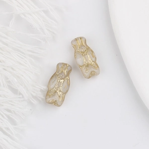 Close-up of vintage translucent owl beads with gold-painted details for DIY jewelry
